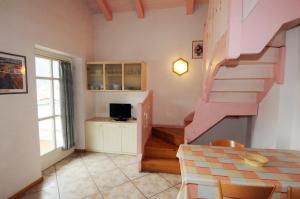 a living room with a pink staircase and a table at Casa Al Mesdì in Pozza di Fassa