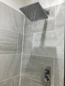 a shower with a shower head in a bathroom at Modern One Bedroom Apartment near the seafront in Portsmouth