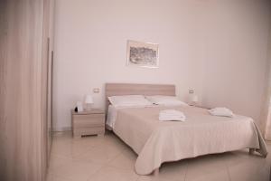 ein weißes Schlafzimmer mit einem großen Bett mit weißer Bettwäsche in der Unterkunft Casa vacanza " I due Angeli " in Matera