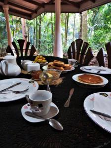 a black table with plates of food and a cup of coffee at Gallene Gala Nature Resort in Kitulgala +68 photos