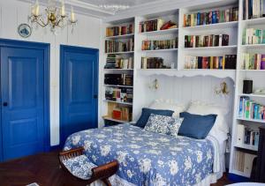 een slaapkamer met blauwe deuren en een bed met boekenplanken bij Het Twiscker Huys in Twisk