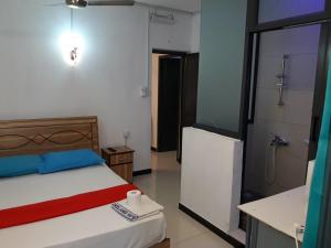 a bedroom with a bed and a bathroom with a refrigerator at Residence Les Bambous in Mahébourg +44 photos