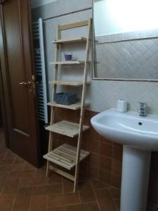 a bathroom with a wooden shelf next to a sink at Casa Vacanze Le Rose in Ariccia
