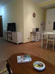 a living room with a table and a tv at Casa Vacanze Le Rose in Ariccia