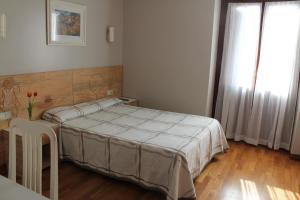 サラウツにあるPensión Lagunakのベッドルーム1室(ベッド1台、テーブル、窓付)
