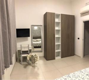 una camera da letto con specchio e sedia di HYGGE Apartment Short Lets a Taranto