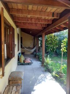 un patio con una hamaca bajo una pérgola de madera en Casa dos Açores Cama e Café en Florianópolis
