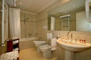 a bathroom with a toilet, sink, and bathtub at Grand Hotel Dei Castelli in Sestri Levante