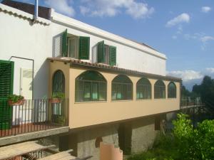 ミラッツォにあるDependance di Villa Elizabeth 4 posti lettoの緑のシャッターとバルコニー付きの建物