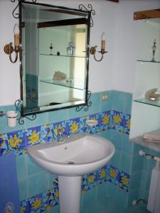 uma casa de banho com um lavatório e um espelho em Dependance di Villa Elizabeth 4 posti letto em Milazzo