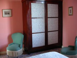 ミラッツォにあるDependance di Villa Elizabeth 4 posti lettoの椅子2脚とガラスの引き戸が備わる客室です。