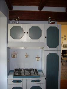 uma cozinha com um fogão e alguns armários azuis e brancos em Dependance di Villa Elizabeth 4 posti letto em Milazzo
