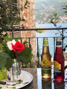 two bottles of beer sitting on a table with a flower at Oldhouse Vucinovic in Tivat +112 photos