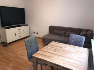 a living room with a table and a couch and a television at Fewo Metzger in Eigeltingen