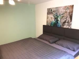 EigeltingenにあるFewo Metzgerのベッドルーム1室(壁に鹿の写真が飾られたベッド1台付)