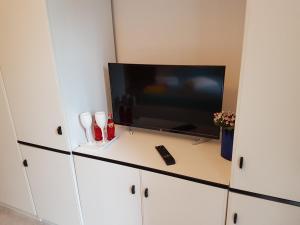 a flat screen tv sitting on top of a white cabinet at Villa Lory Albinia in Albinia