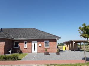 a red brick house with a white door at Ferienhus Wattkinner in Tönning