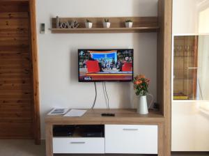 En tv och/eller ett underhållningssystem på Comfort Apartment No. 16, Daffodil Court