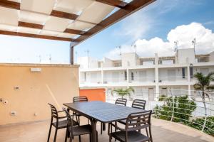 un tavolo e sedie su un balcone con un edificio di Villino IlMareChiama a Torre Lapillo