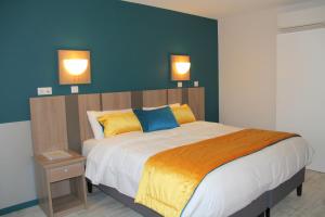 a bedroom with a large bed with two lights on the wall at Logis Hotel Restaurant Le Grand Turc in LʼOie