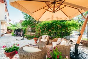 eine Terrasse mit Stühlen und einem Tisch mit einem Sonnenschirm in der Unterkunft Reiss Hotel in Feodossija