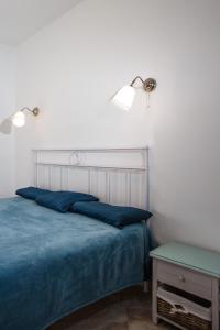 een slaapkamer met een bed met blauwe lakens en een tafel bij Koi Seaview apartment in Herceg-Novi