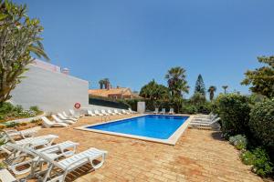 a swimming pool with lounge chairs and a swimming pool at Casa Silver in Carvoeiro