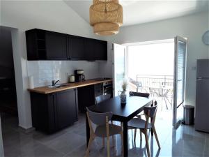 a kitchen with black cabinets and a table and chairs at Apartments Dolores in Senj