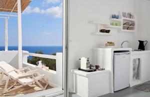 a kitchen with a white refrigerator and a balcony at Vista Mare Milos in Provatas