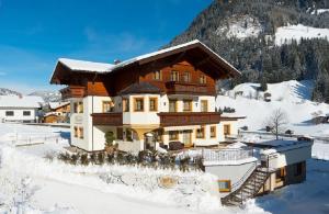 ein Haus im Schnee mit einem Berg in der Unterkunft Wallnerhof in Großarl