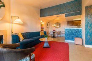 Una sala de estar con un sofá azul y una mesa. en Luxury Modern Condo 2, en Las Vegas