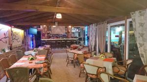 a restaurant with tables and chairs and a bar at Christakis in Sidari