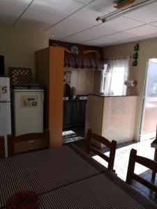 eine Küche mit einem Tisch und eine Küche mit einem Kühlschrank in der Unterkunft Ca la Pilar in El Poble Nou del Delta