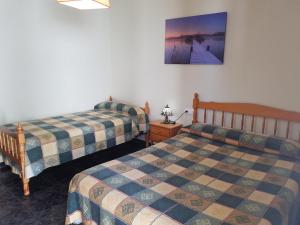ein Schlafzimmer mit 2 Betten und einem Bild an der Wand in der Unterkunft Ca la Pilar in El Poble Nou del Delta