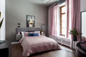 um quarto com uma cama com almofadas cor-de-rosa e azuis em Maison Saint-Vincent By Maisons & co em Montreal