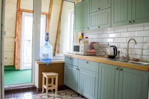 a kitchen with green cabinets and a bottle of water at Hostel Tarnopil in Ternopil
