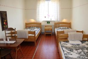 a room with three beds and a table and a window at Järjagården Hostel in Storsele