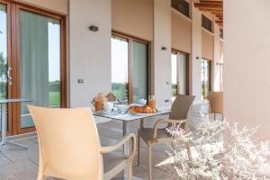 a dining room with a table and chairs and windows at Agriturismo Ca' Giulietta in Sommacampagna