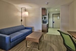 a living room with a blue couch and a table at Holiday Inn Express & Suites Portales, an IHG Hotel in Portales