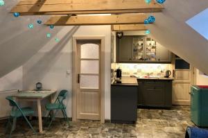 a kitchen with an attic with a table and chairs at Guest House K74 in Jablonné v Podještědí