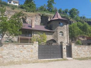 un edificio con una puerta frente a una pared de piedra en Smotrytska Vezha, en Kamianets-Podilskyi