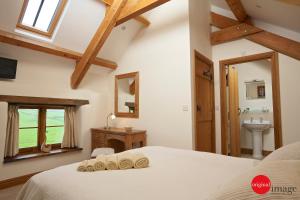 a bedroom with a bed and a sink and a mirror at Jacks Cottage in Totnes