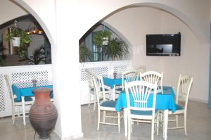 une salle à manger avec une table bleue et des chaises dans l'établissement Hotel Andreas, à Kamari