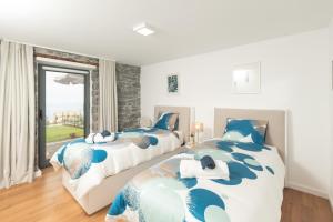 twee bedden in een slaapkamer met een raam bij BHF Residences Ying Yang in Calheta
