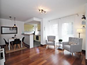 a living room with a table and chairs and a kitchen at Apartamento Monte Perdido in Boltaña