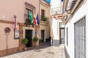 um beco estreito com bandeiras num edifício em Hotel Patio de las Cruces em Sevilha
