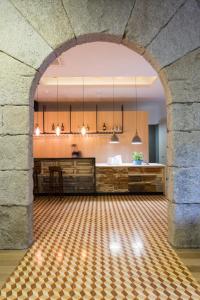an archway in a room with a kitchen and a table at Original Douro Hotel in Peso da Régua