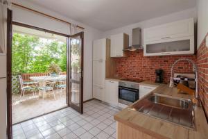 a kitchen with a sink and a patio with a table at Villaina in Komiža