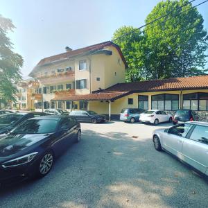 un estacionamiento con autos estacionados frente a un edificio en Hotel Lucija, en Most na Soči