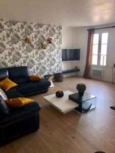 ein Wohnzimmer mit einem Sofa und einem Tisch in der Unterkunft Appartement vue sur mer île de ré in Rivedoux-Plage